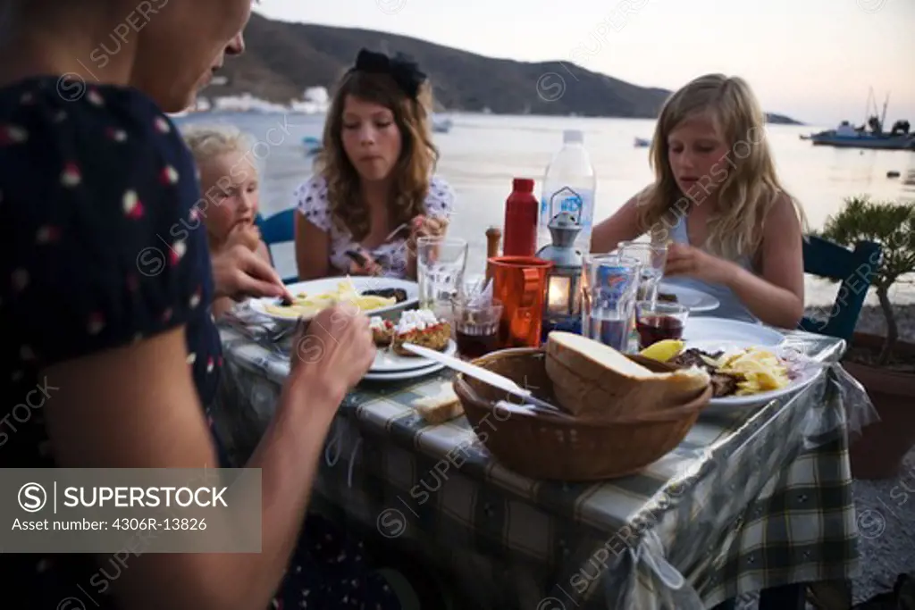 Scandinavian family having dinner, Greece.