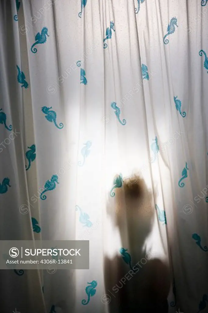 Scandinavian girl behind a shower curtain.