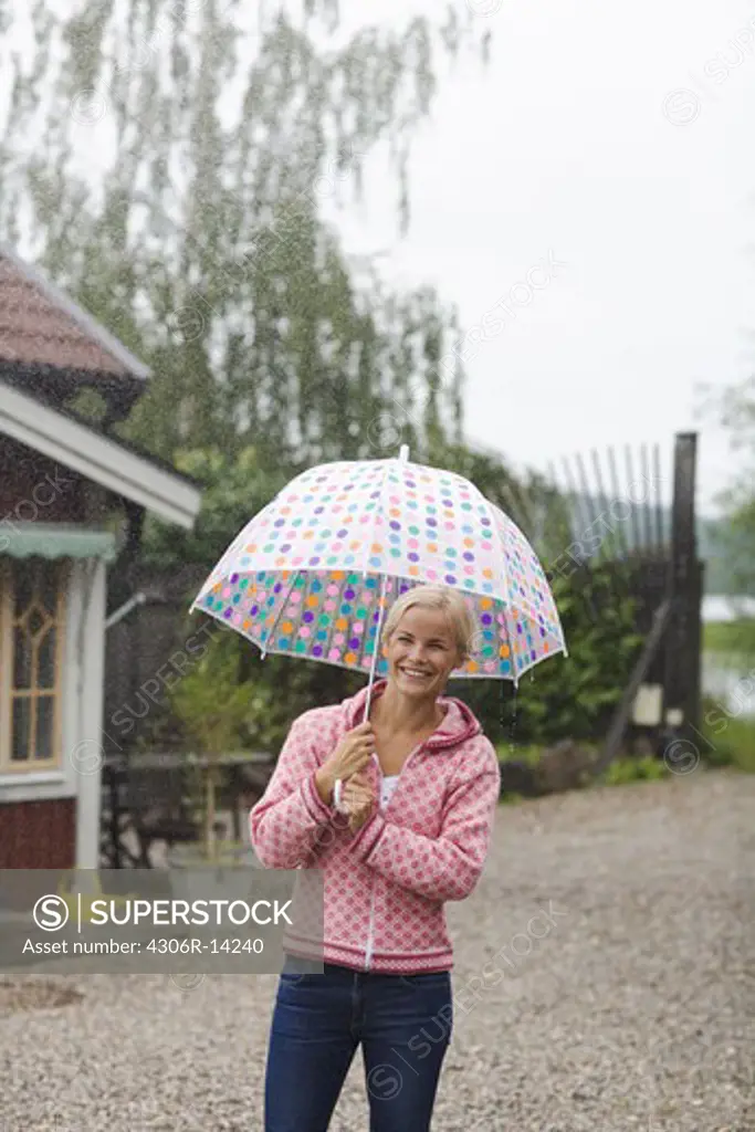 A woman standing under an umbrella, Sweden.