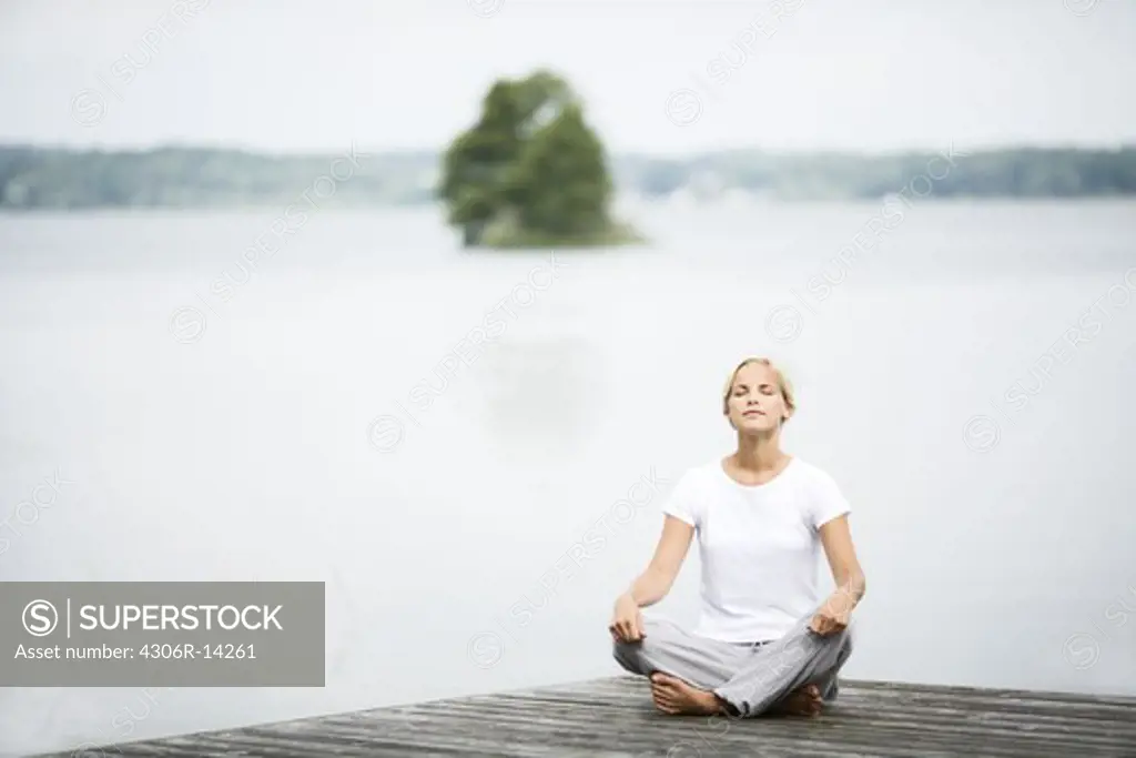 A woman sitting on a jetty, Sweden.