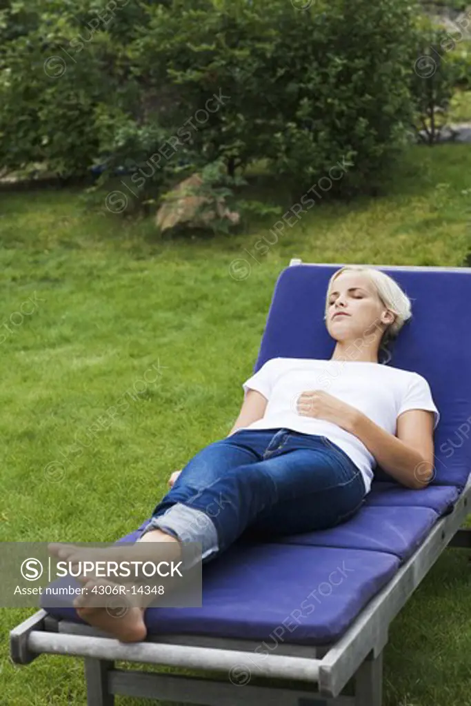 A woman resting on a sun chair, Sweden.