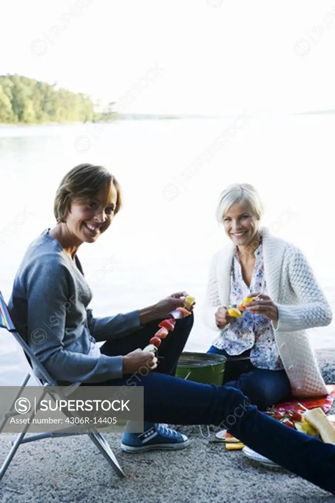 Two women having a picnic by the sea in the archipelago of Stockholm, Sweden.