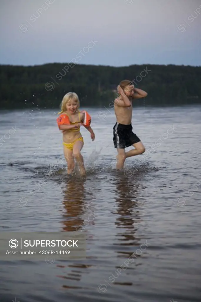 A boy and a girl having a dip at night, Varmland, Sweden.