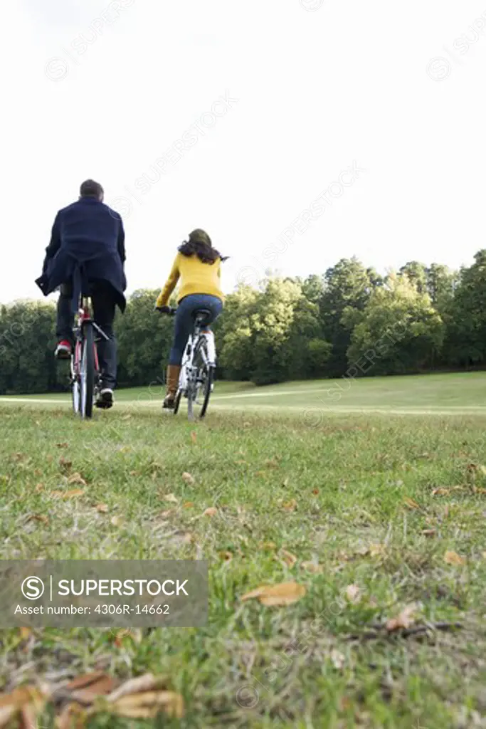 A woman and a man riding a bike an autumn day, Sweden.