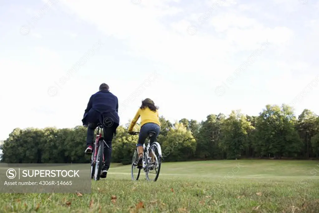 A woman and a man riding a bike an autumn day, Sweden.