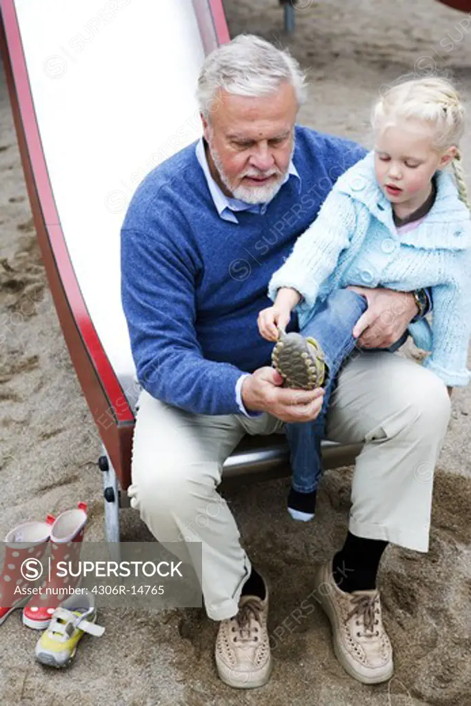 Grandfather and grandchild on a playground, Sweden.