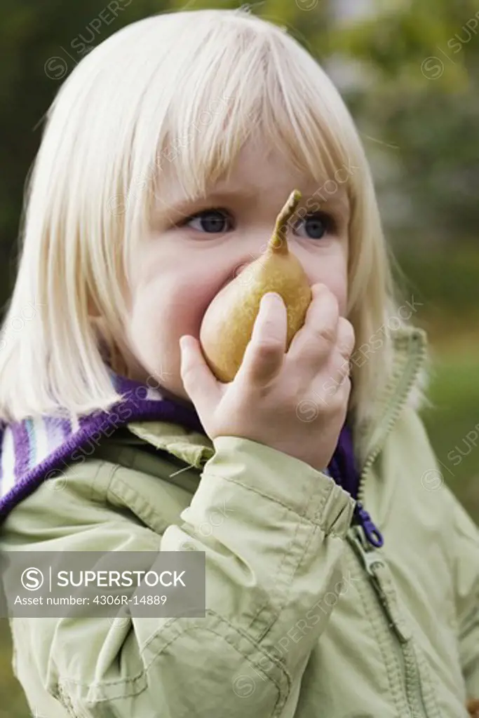 A girl eating a pear, Nacka, Sweden.