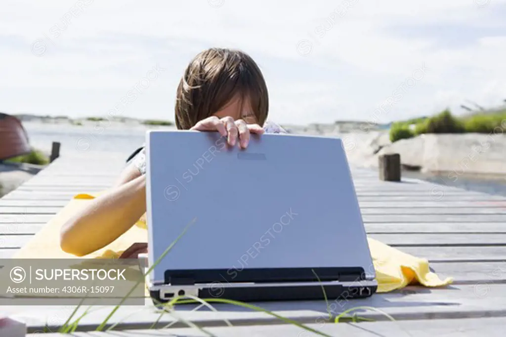 A scandinavian woman with a laptop in the archipelago, Sweden.