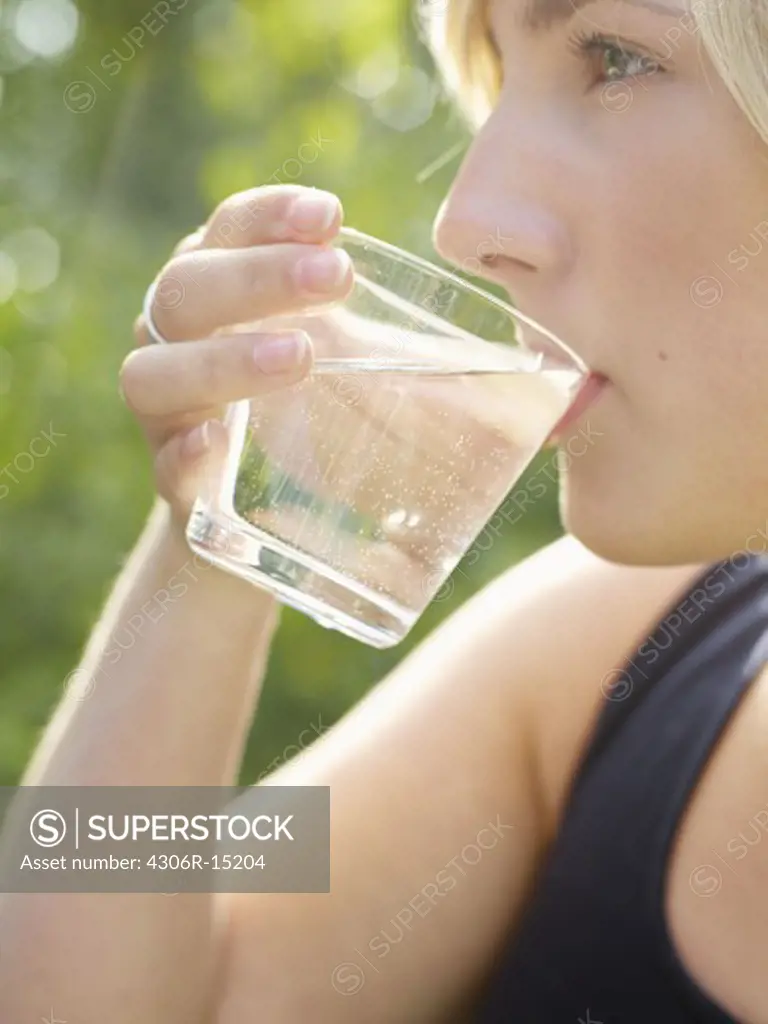 A young woman drinking water, Sweden.