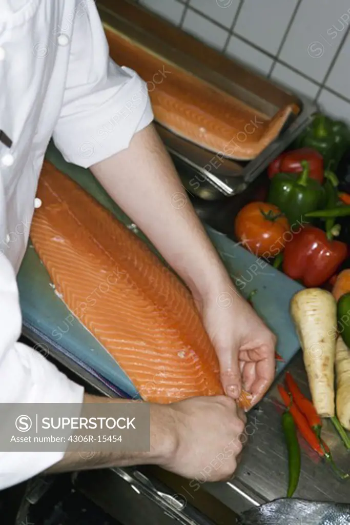 A cook preparing food in a restaurant kitchen, Sweden.