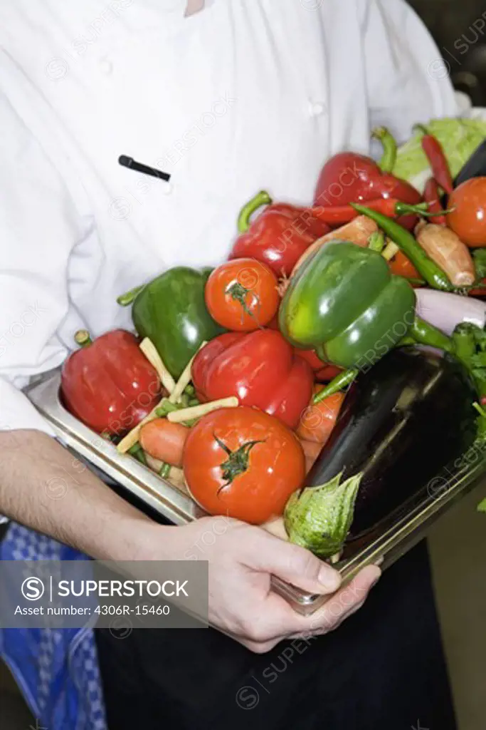 A cook preparing food in a restaurant kitchen, Sweden.