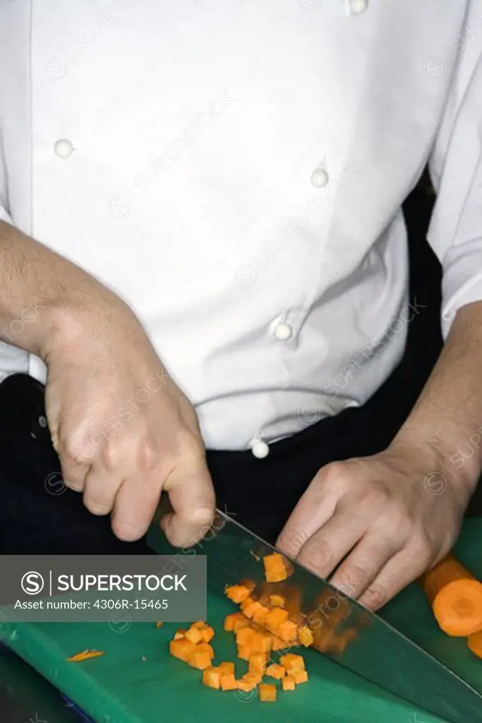 A cook preparing food in a restaurant kitchen, Sweden.
