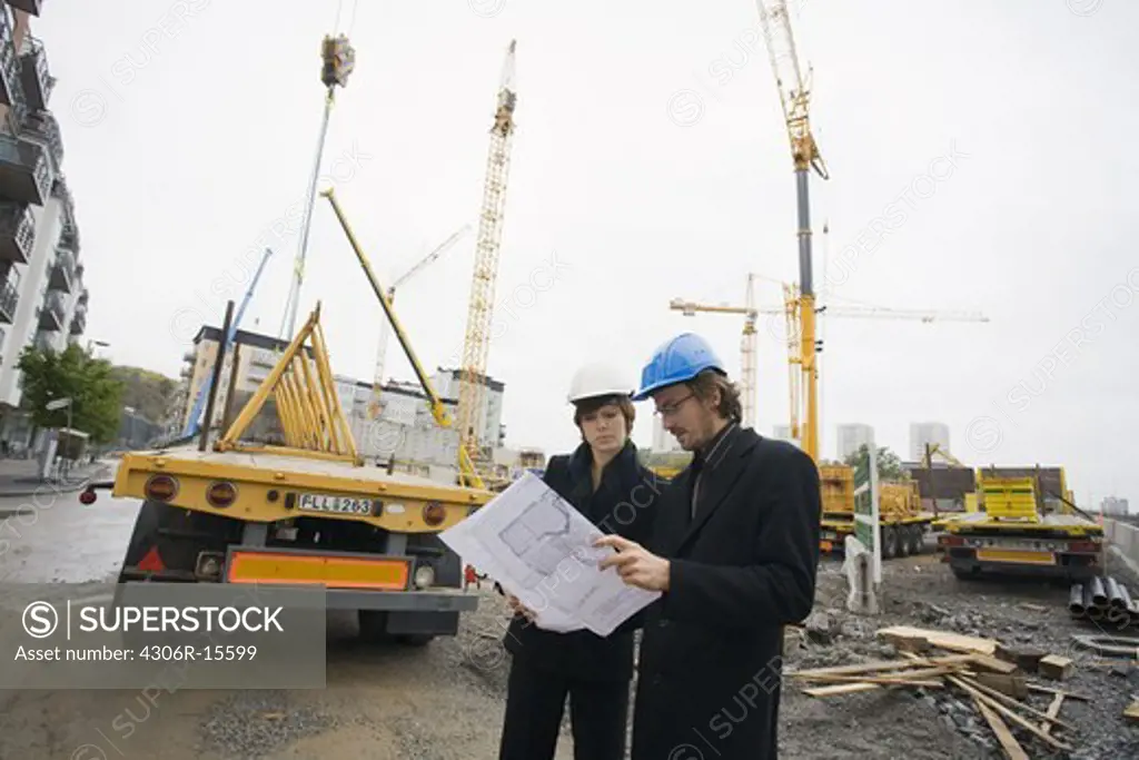 Project leaders at a building site, a man and a woman, Sweden.