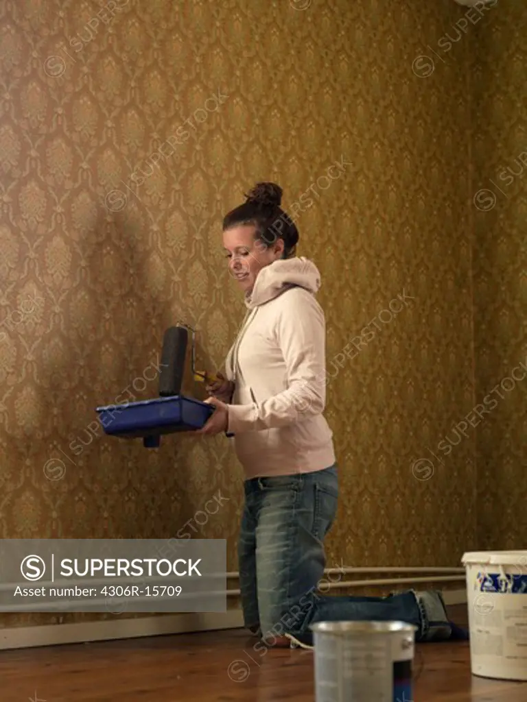 A young woman renovating a room, Sweden.