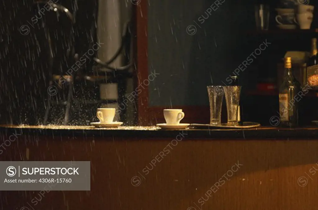 Rain over coffee cups in a cafe.
