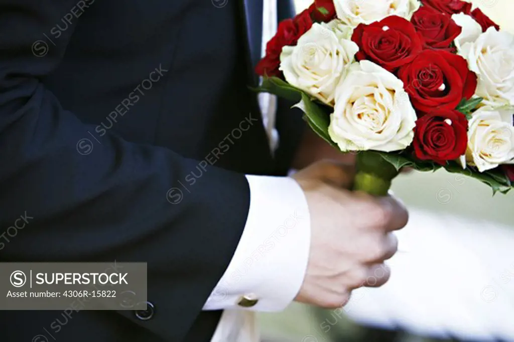 A bridegroom holding wedding bouquet, Sweden.
