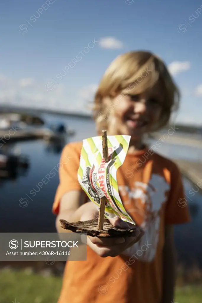 A boy holding a bark boat, Sweden.