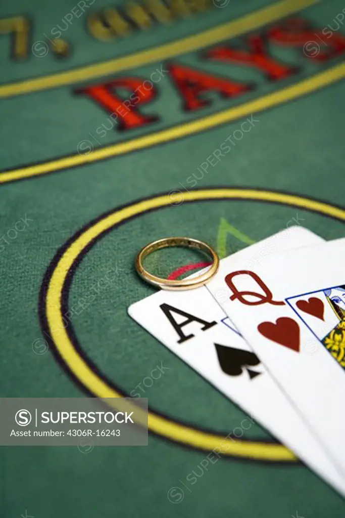 Playing cards and an engagement ring at a gambling table.