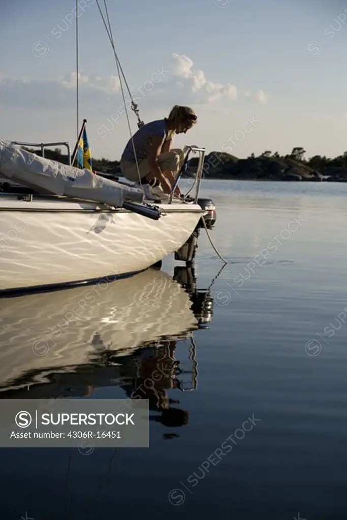 A woman sitting on a sailing-boat, Ostergotland, Sweden.
