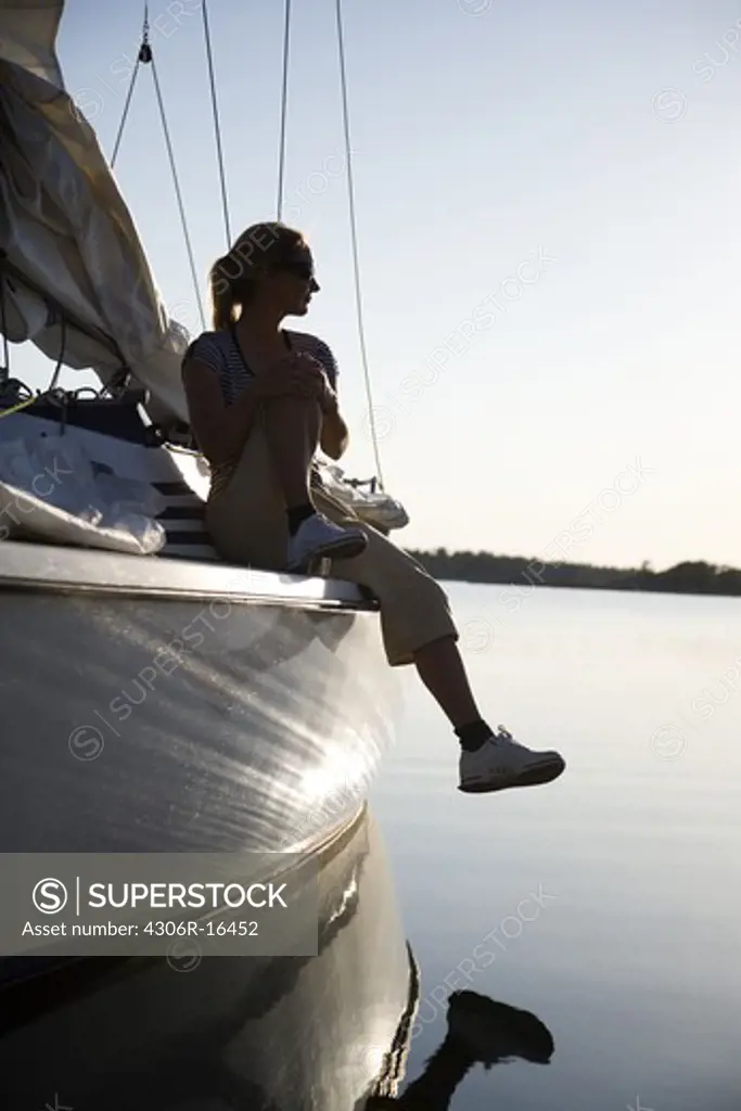 A woman sitting on a sailing-boat, Ostergotland, Sweden.