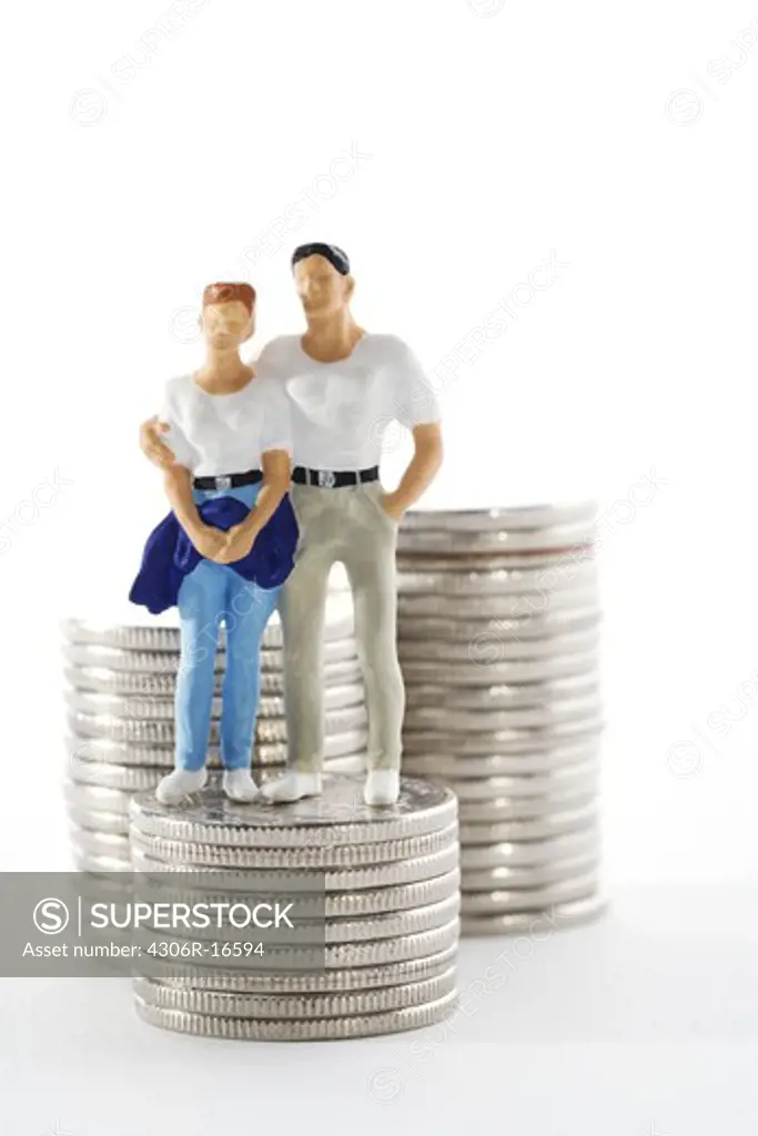 Figures in the shape of a couple standing next to a bunch of money.