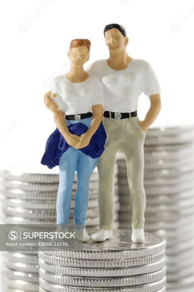 Figures in the shape of a couple standing next to a bunch of money.