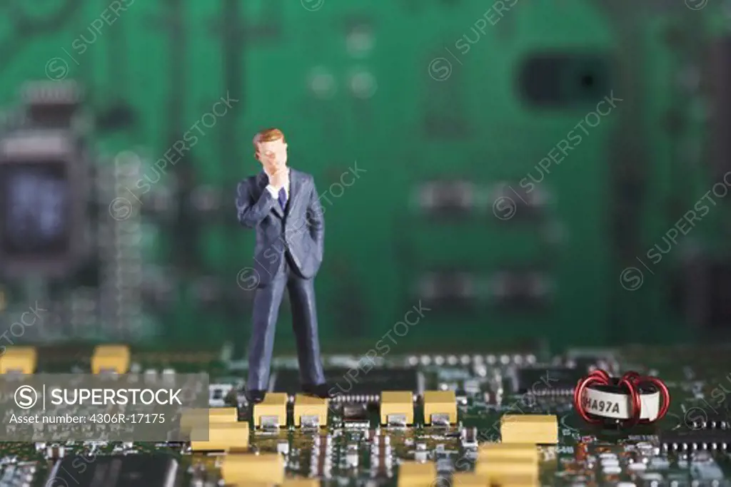 Figure in the shape of a business man standing in a printed circuit card.