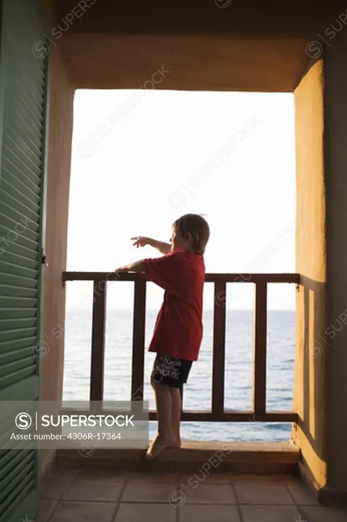 A boy standing on a terrace, Greece.