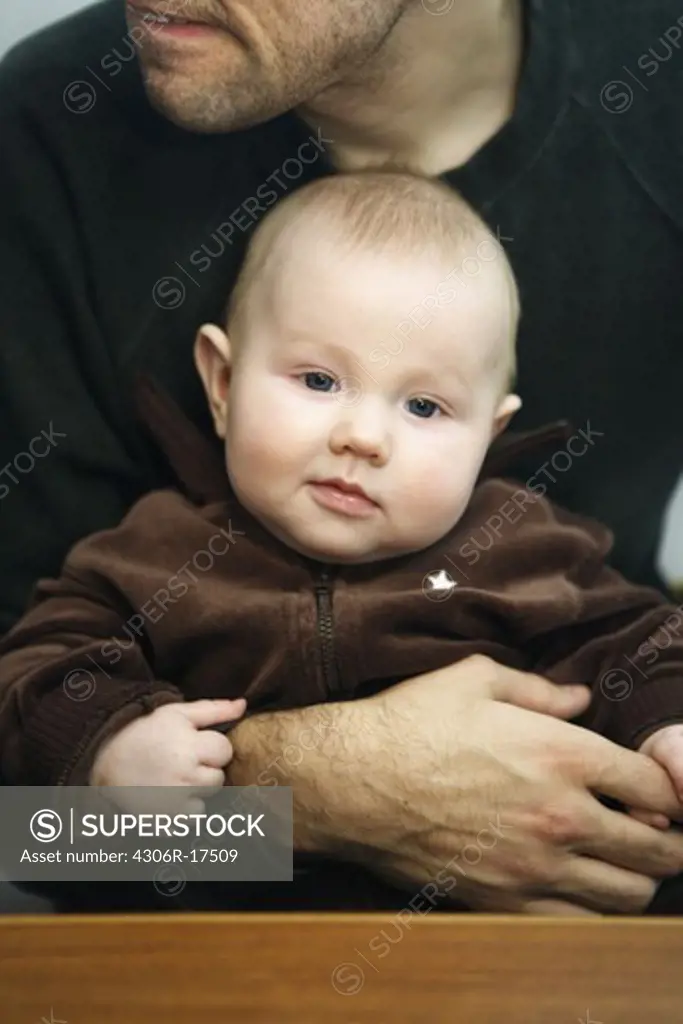 A boy sitting in his fathers lap, Sweden.