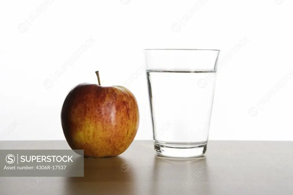 An apple and a glass of water.