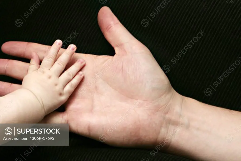 A big and a small hand, close-up.