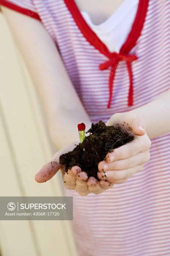 A girl holding a plant, close-up, Sweden.