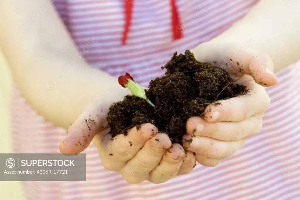 A girl holding a plant, close-up, Sweden.