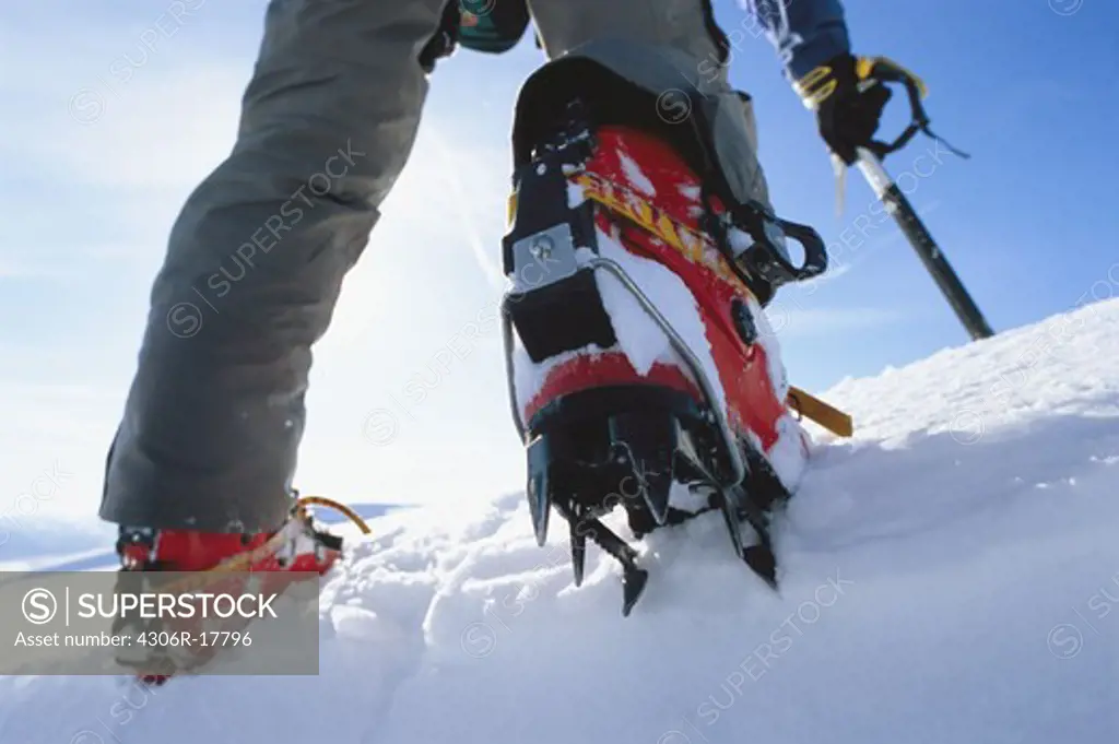 Low section of person wearing crampons