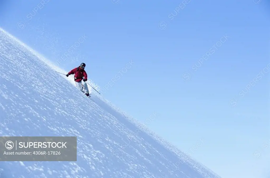 Person telemark skiing on steep mountain slope