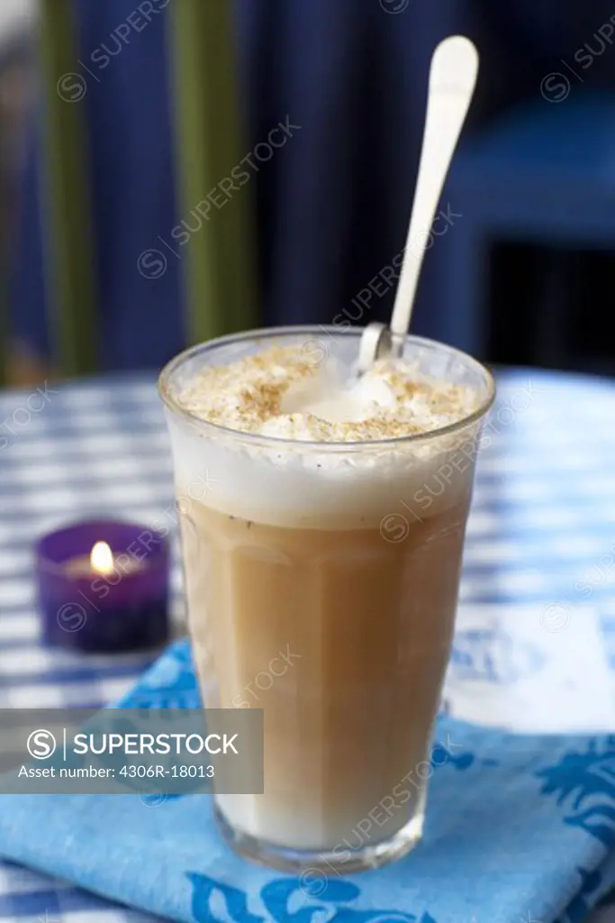 A glass of Cafe ou lait on a table.