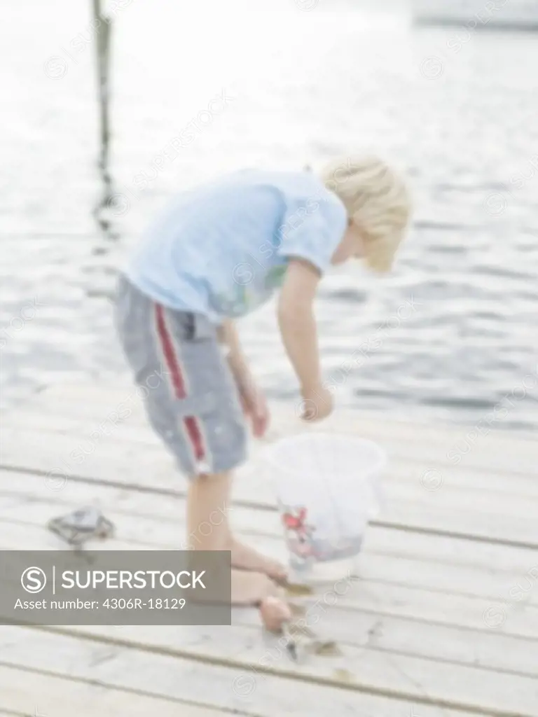 Scandinavian boy on a jetty, Sweden.
