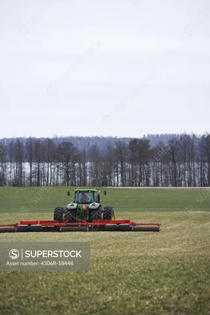 Tractor with roller in a field, Sweden.