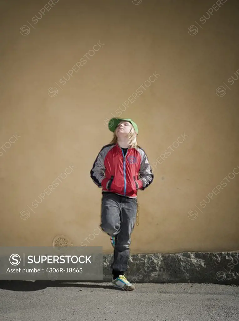 A boy standing in front of a wall, Sweden.