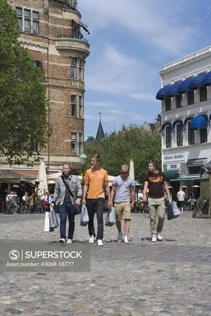 Four young men with shopping bags in Malmo, Sweden.