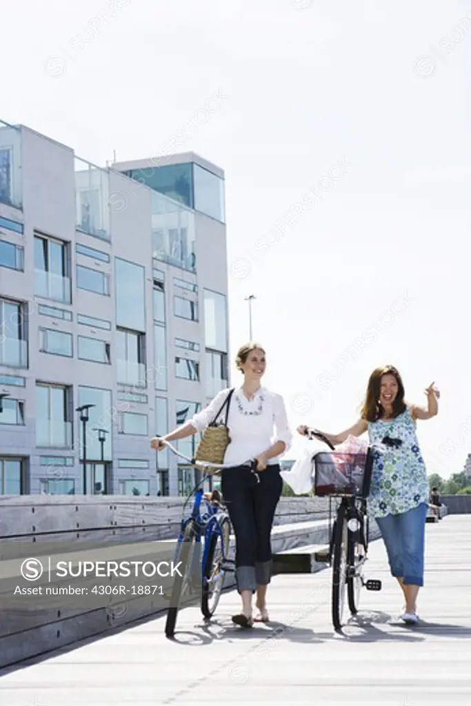 Two women riding bikes, Skane, Sweden.
