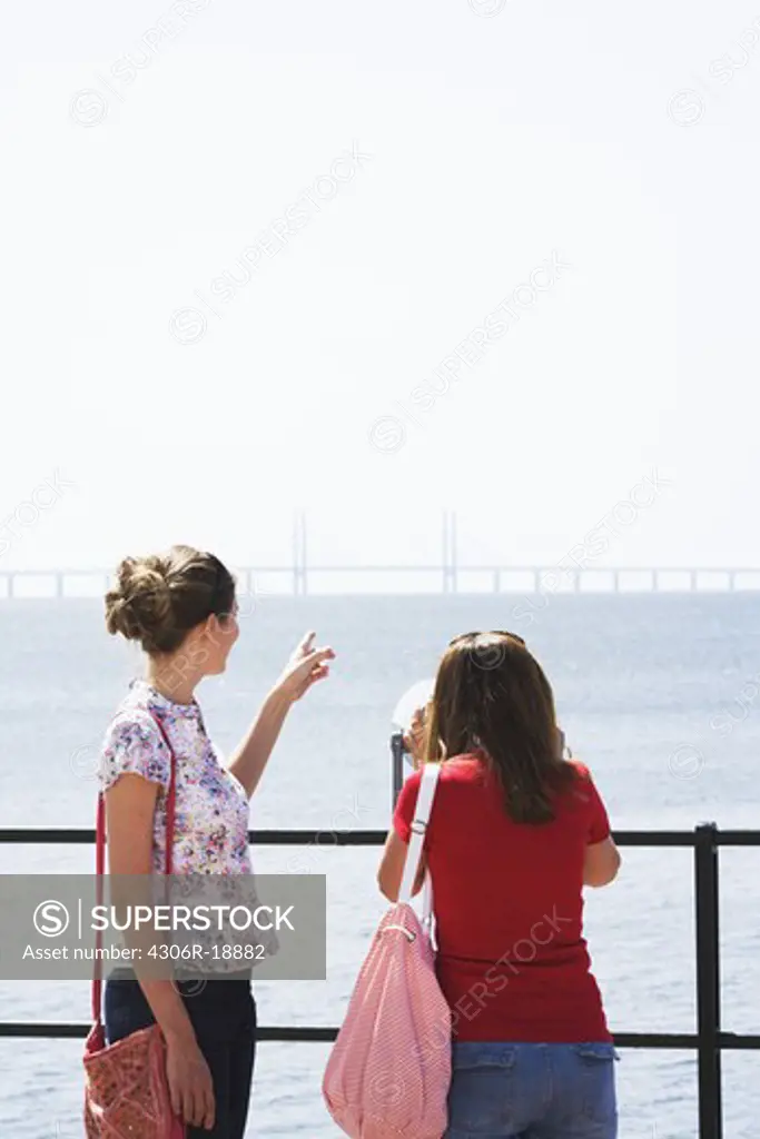 Two women admiring the Oresund bridge, Skane, Sweden.