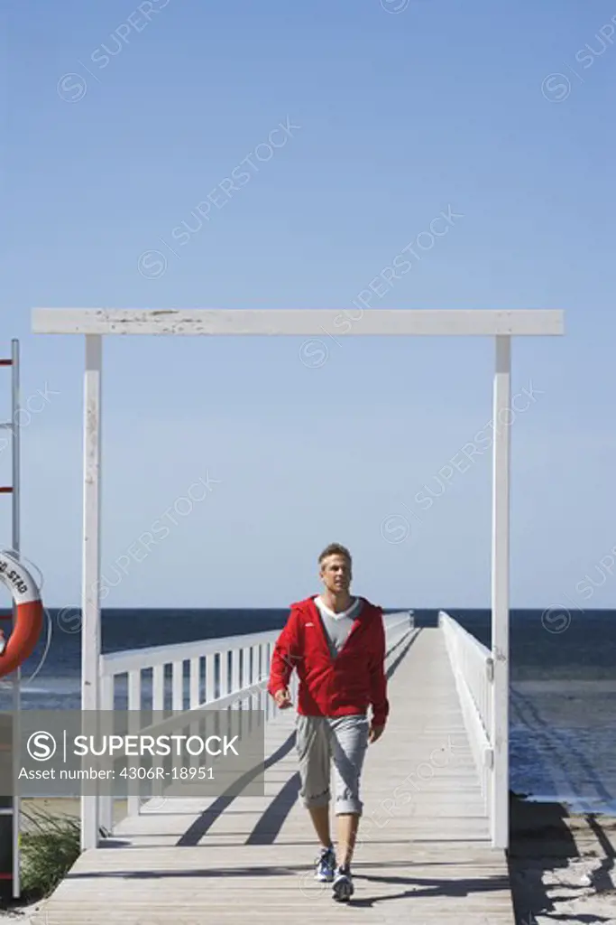 A man walking on a jetty, Malmo, Skane, Sweden.