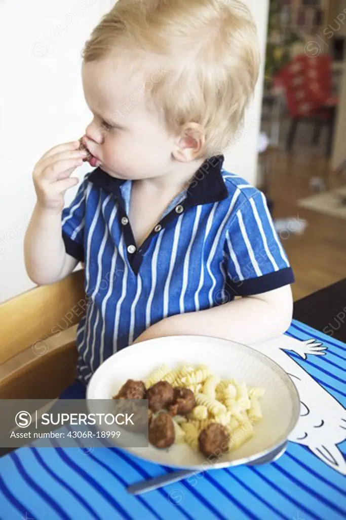 A boy eating meatballs, Sweden.
