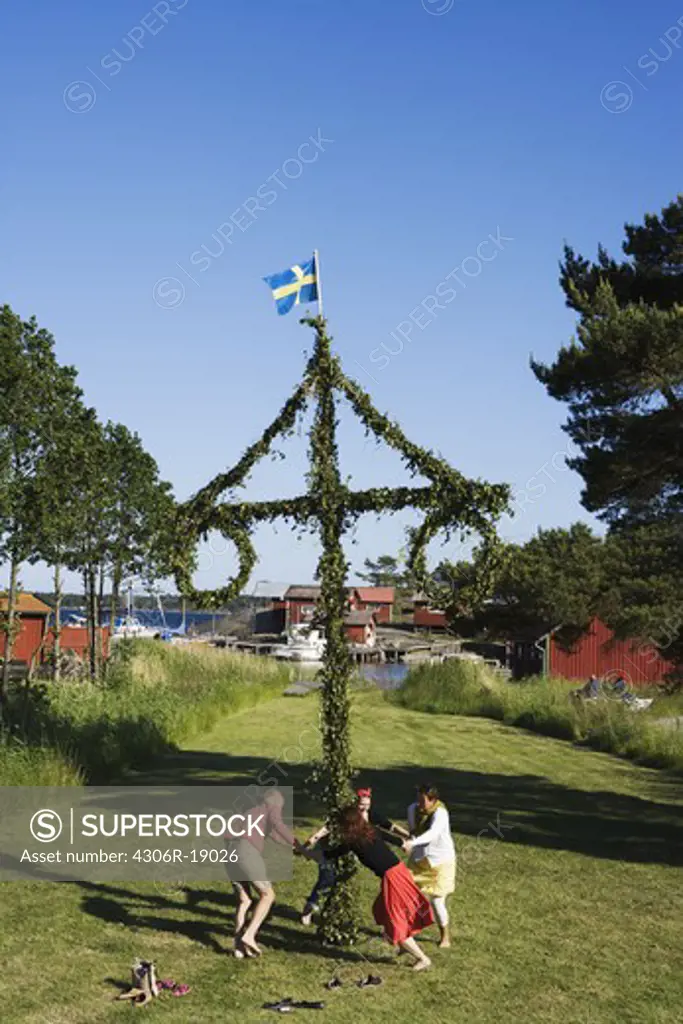 People dancing around the maypole for midsummer, Sweden.