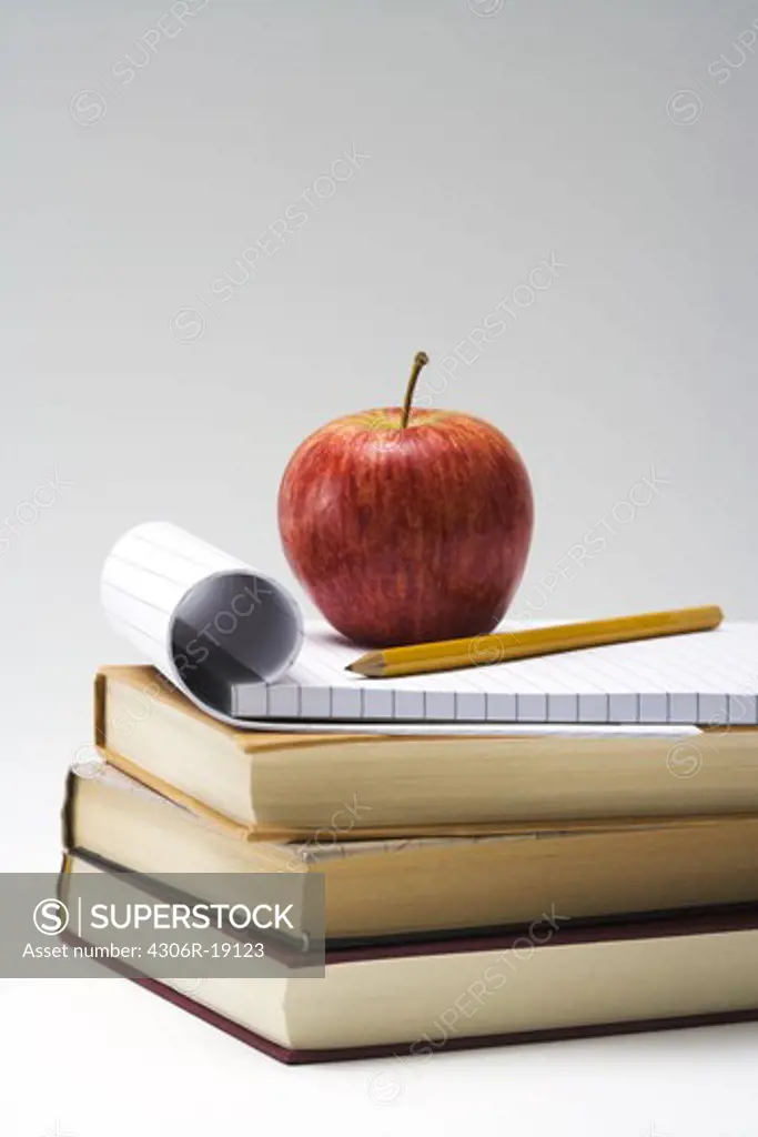 A red apple and books, close-up.
