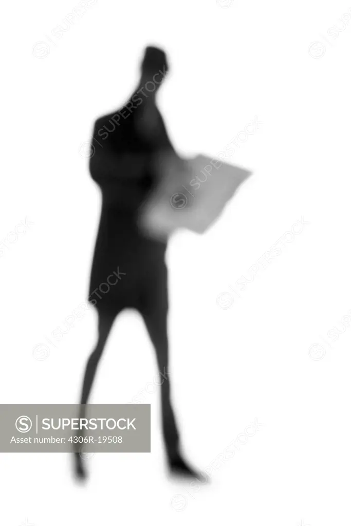 Silhouette of a man reading the paper.