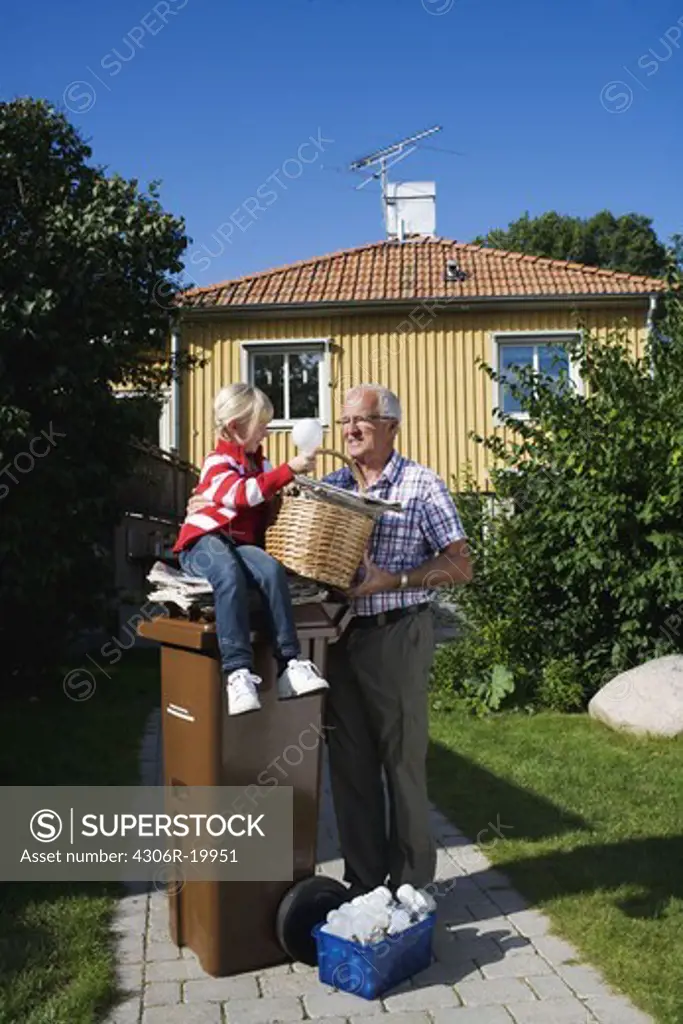 Grandfather and granddaughter by a dustbin, Sweden.