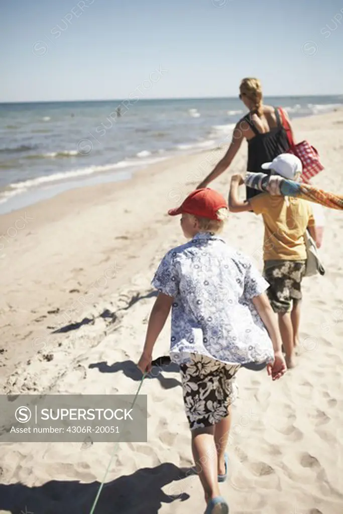 Mother and sons walking on a beach, Gotland, Sweden.