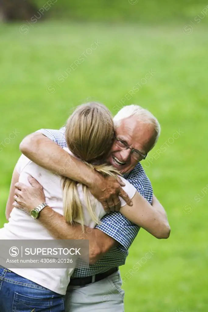 Woman and senior man embracing each other, Sweden.